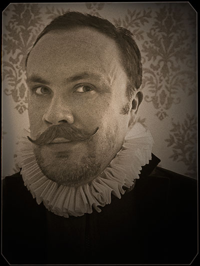 Alistair Gentry in Elizabethan dress, including a white, starched ruff.